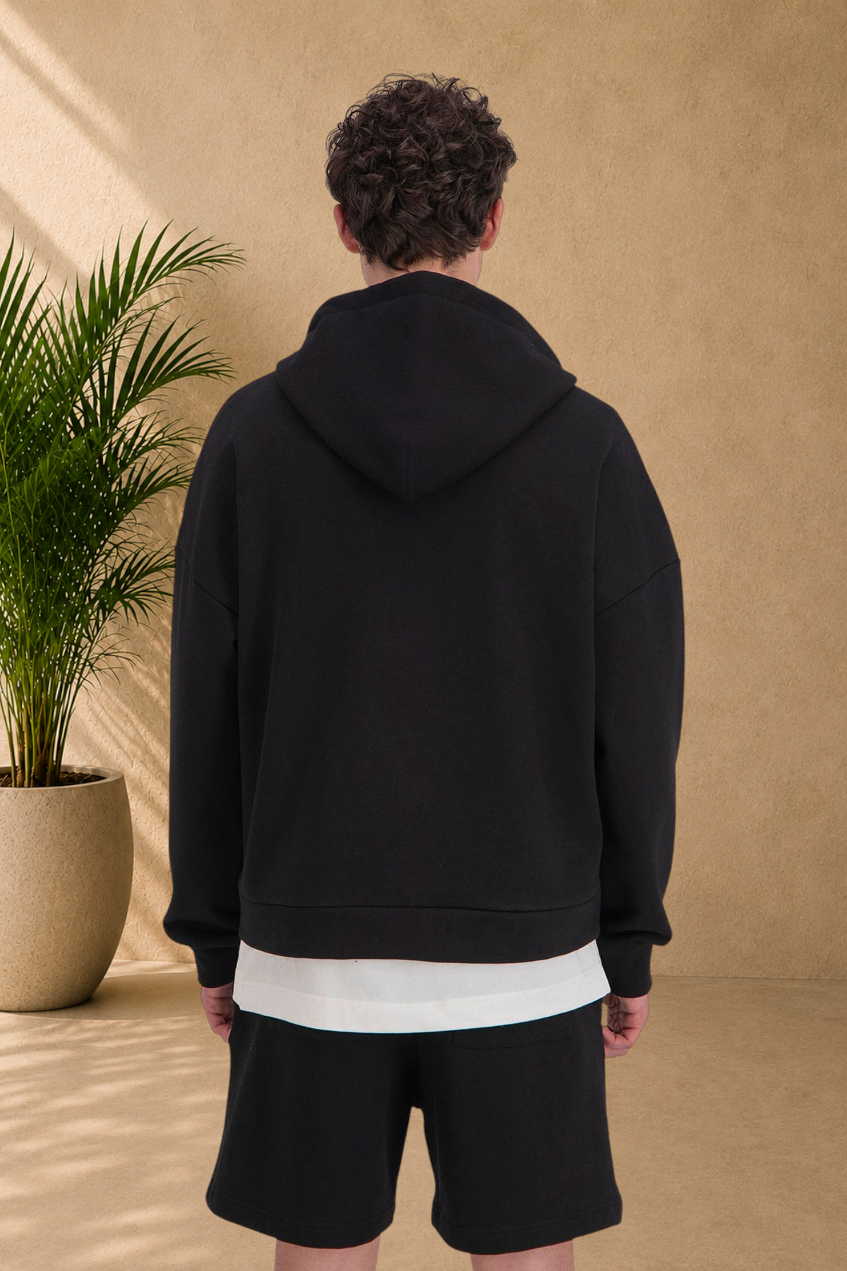 Stayin black quilted zip-up hoodie worn by a model, back view showing thick fabric and comfortable fit