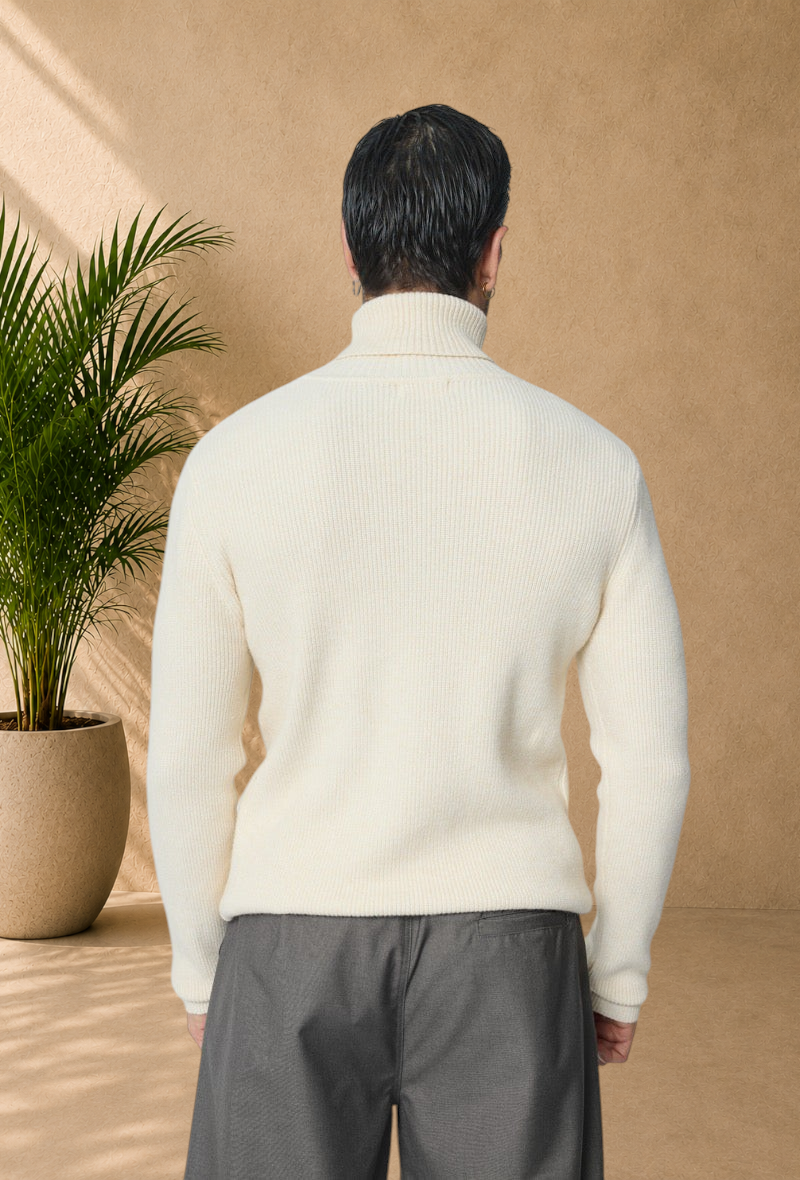 Back view of a man wearing a Stayin ivory ribbed knit turtleneck sweater with a modern fit.