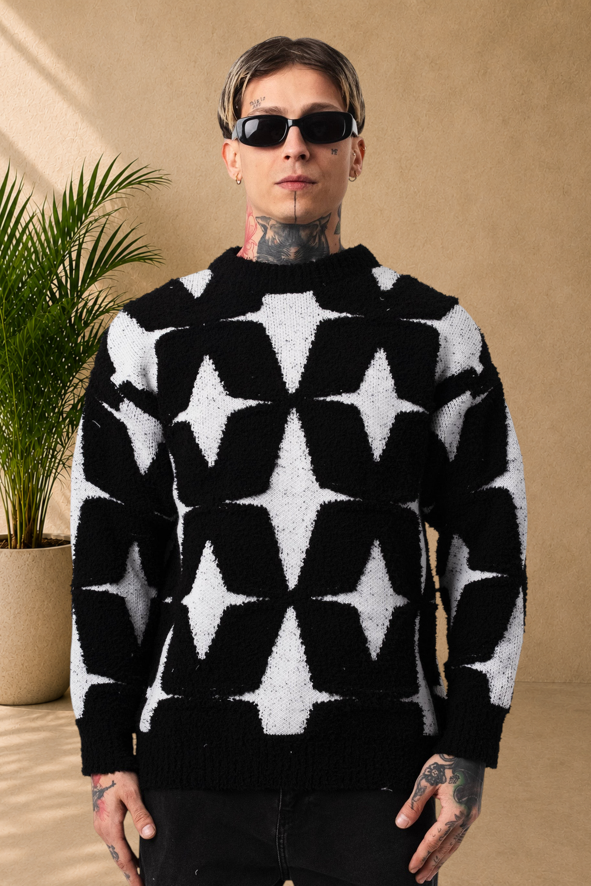 Stayin fluffy crew neck sweater with black and white star pattern worn by a model with tattoos and sunglasses