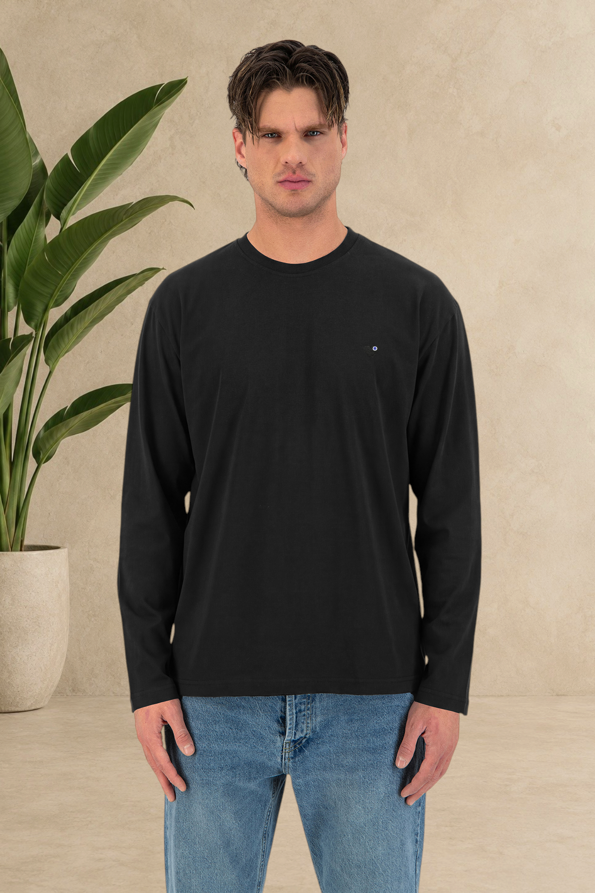 Mannequin portant un t-shirt Stayin noir à manches longues, coupe ample et col rond avec logo discret sur la poitrine