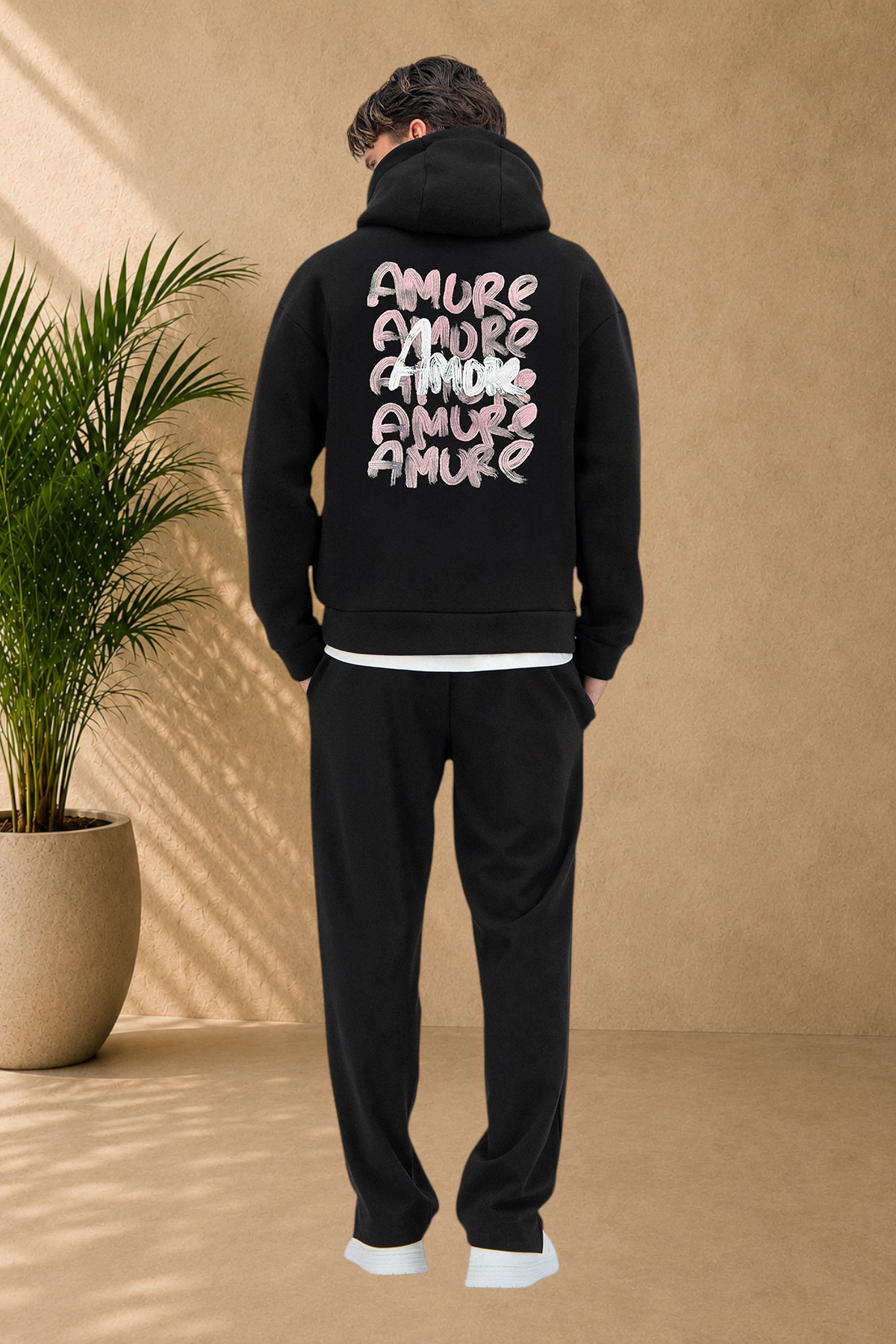 Stayin black quilted hoodie with Amore graphic print on the back worn by a model