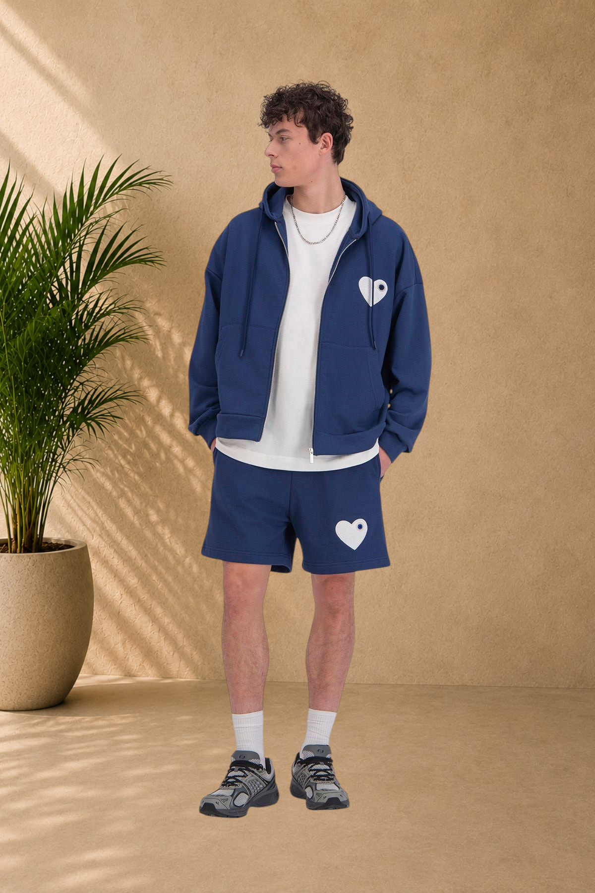 Stayin blue zip-up hooded sweatshirt and matching shorts set with white heart logo worn by a male model