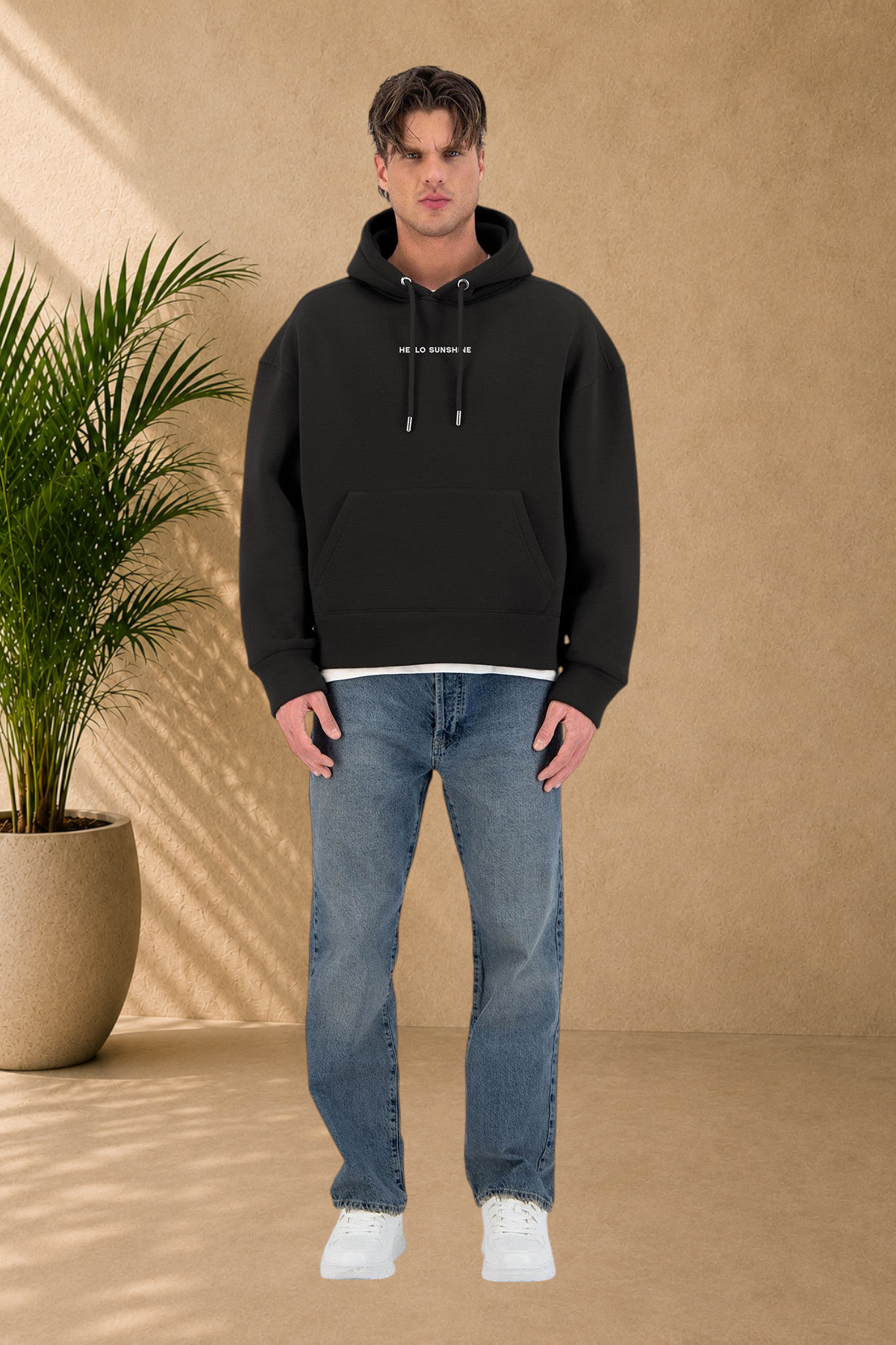 Stayin black quilted hoodie with Hello Sunshine text, worn by a male model with blue jeans and white sneakers