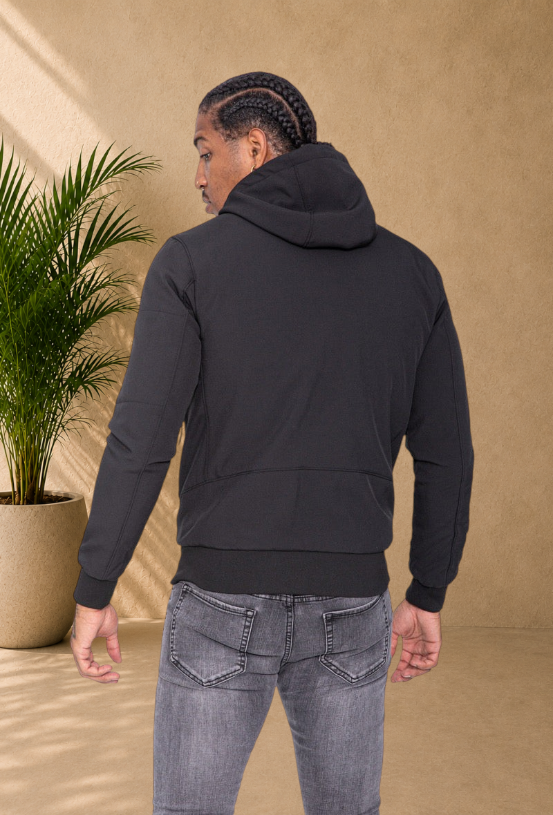 Stayin black hooded windbreaker jacket worn by a man, back view, showing fitted design and ribbed cuffs