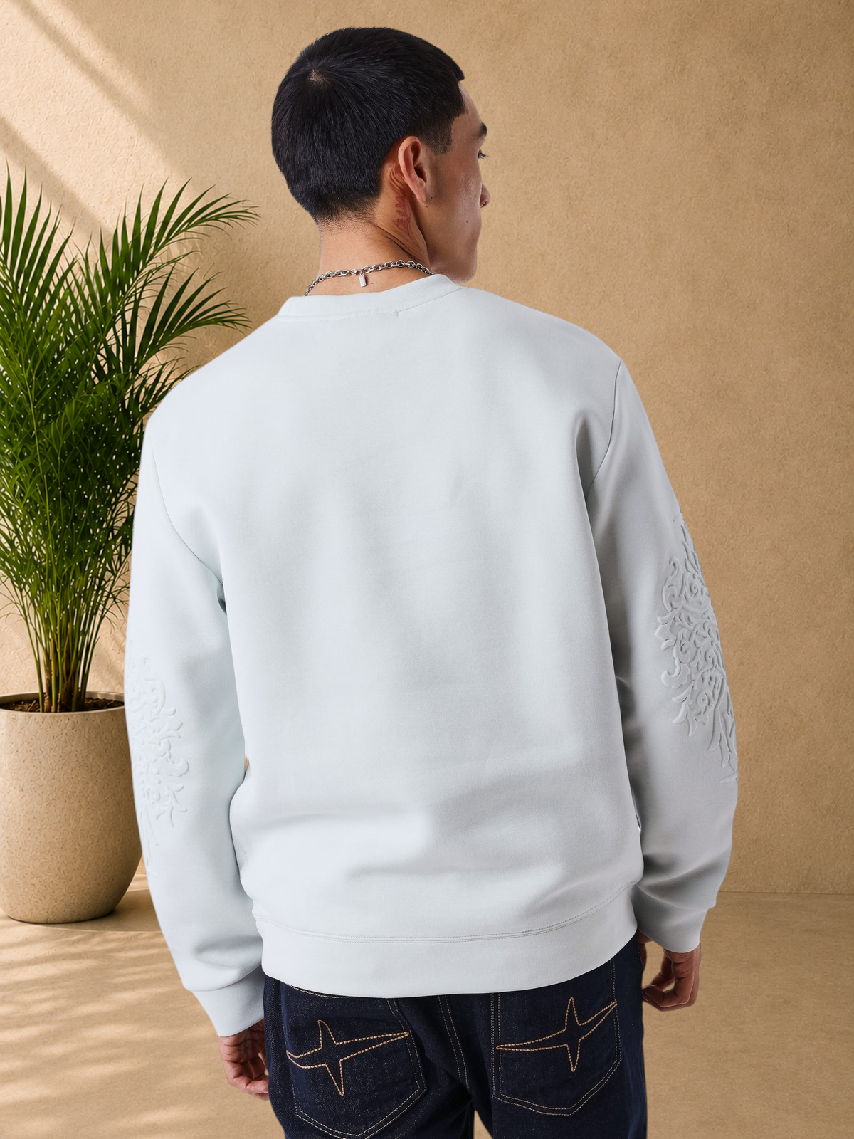 Stayin light grey regular fit sweatshirt with embossed sleeve detail worn by a man, back view