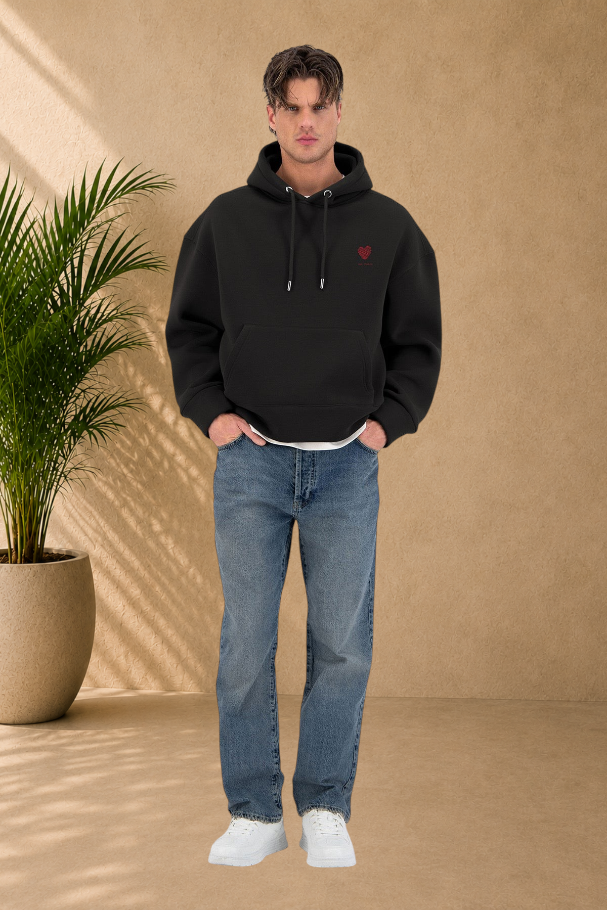 Stayin black quilted hoodie with red heart embroidery worn by a male model with blue jeans and white sneakers