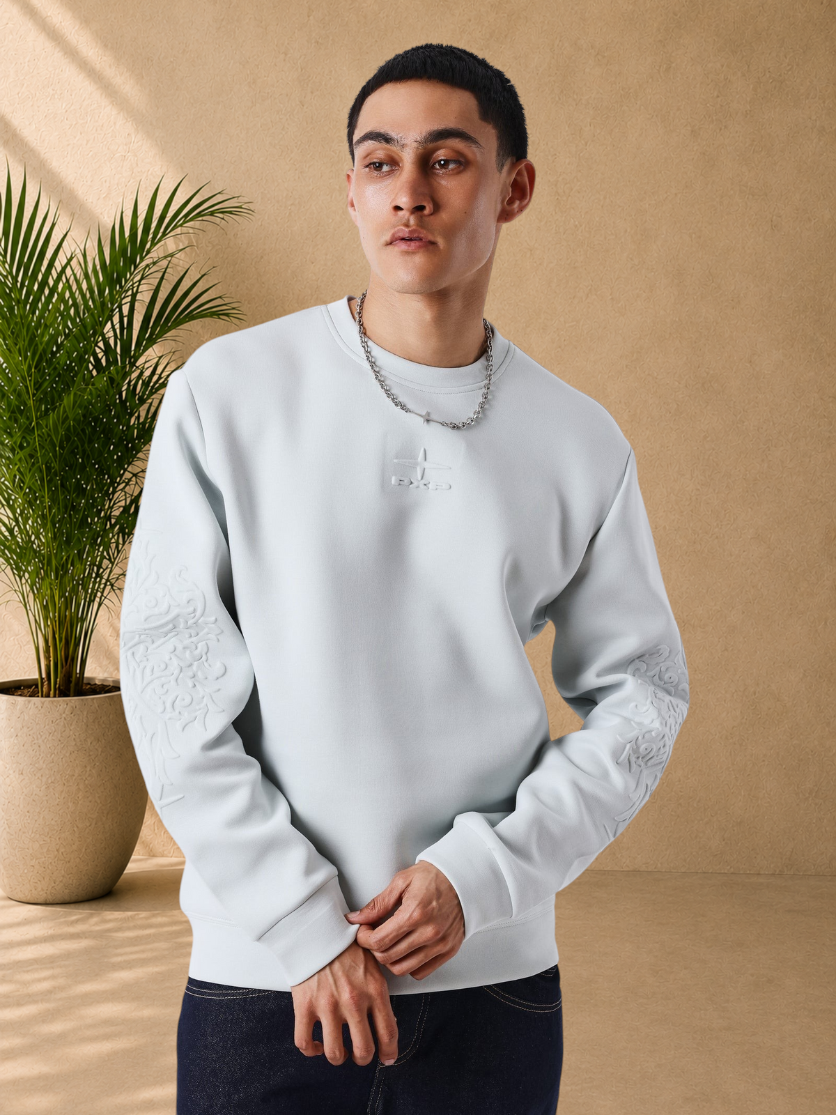 Stayin light grey regular fit sweatshirt with embroidered chest logo and embossed sleeve patterns on a male model
