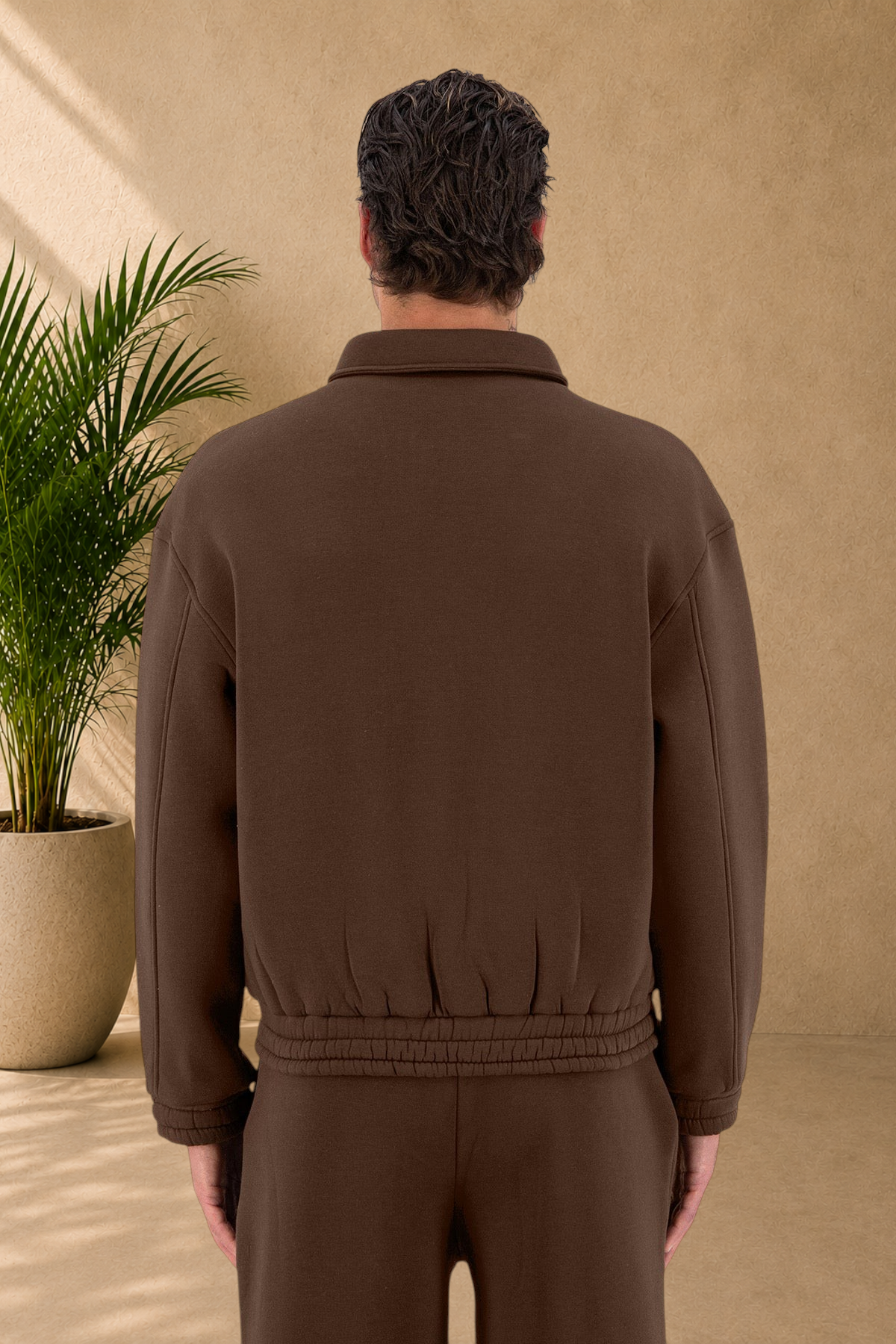Stayin brown oversized padded jacket with a collar and ribbed hem worn by a model, back view