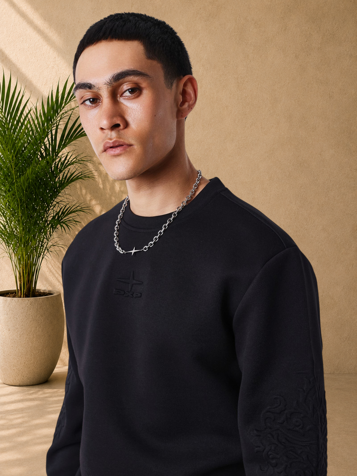 Stayin black regular fit crew neck sweatshirt with tonal embroidered logo and embossed sleeve pattern on a model