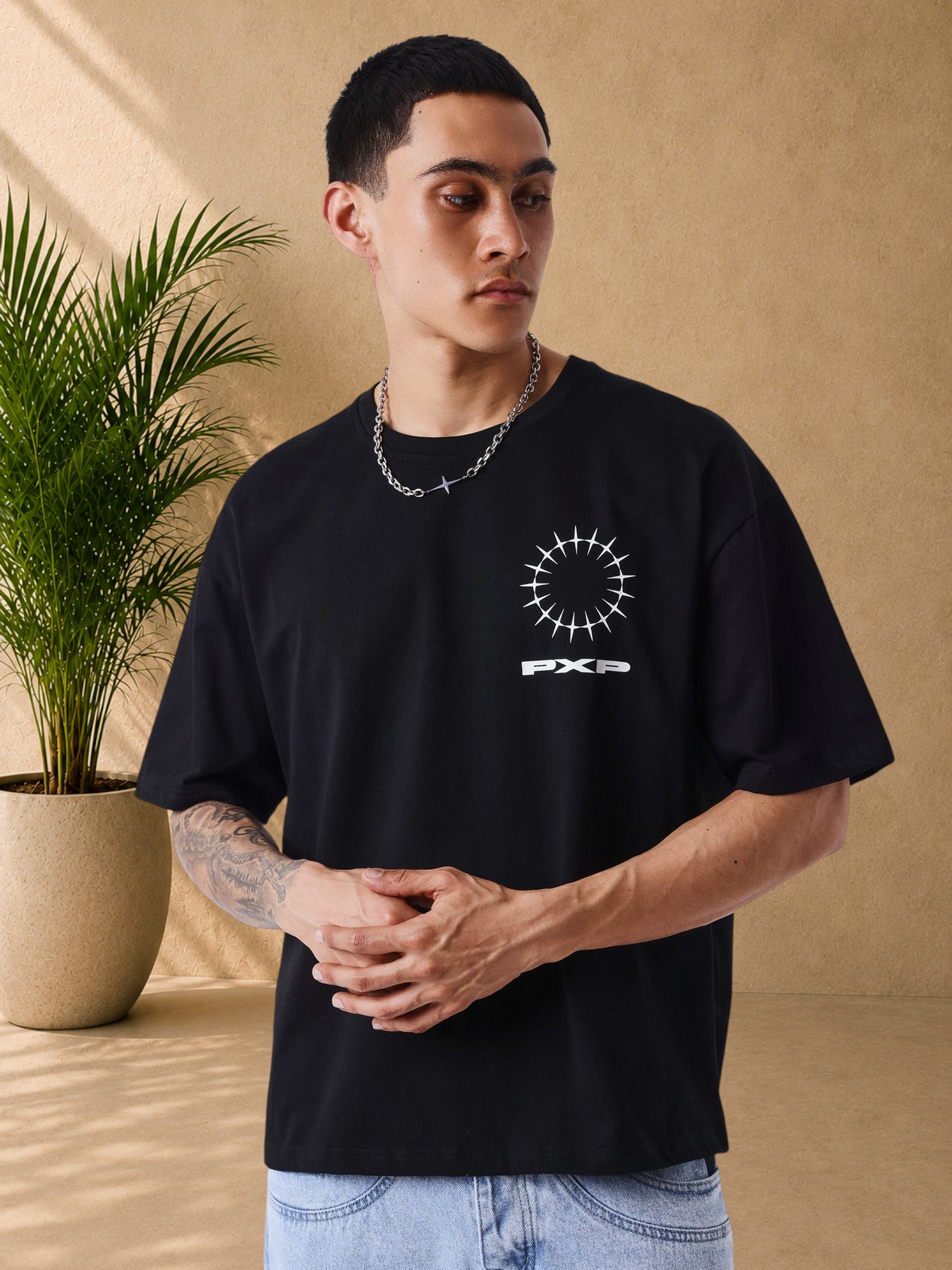 Stayin PXP black oversized cotton t-shirt with white graphic logo on chest worn by a model