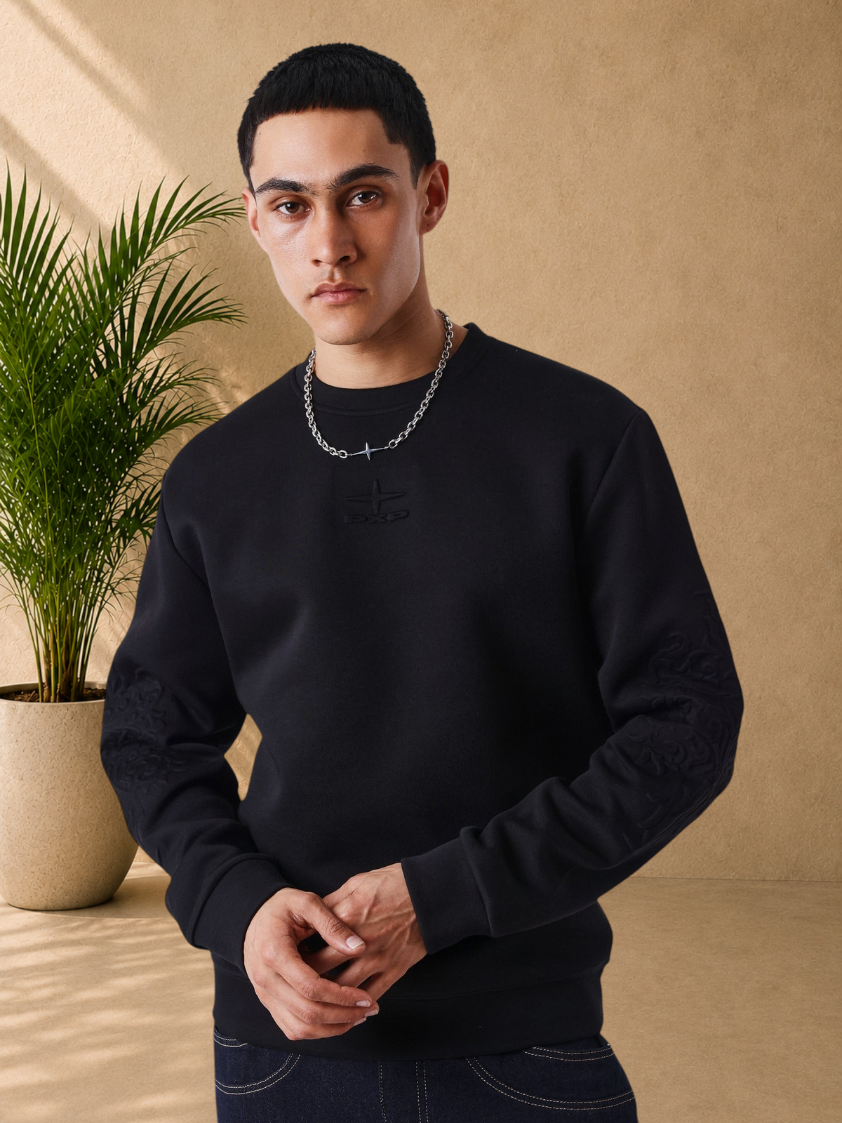 Stayin black regular fit crewneck sweatshirt with tonal embroidered PXP logo and embossed sleeve detail on a model
