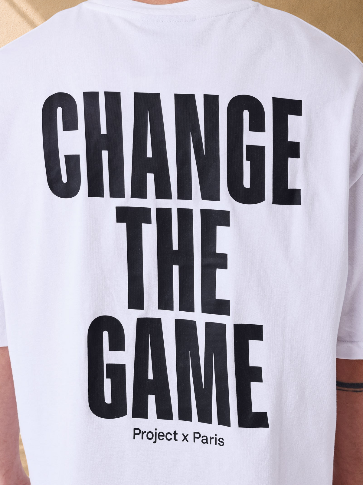 Stayin white boxy cotton t-shirt with black Change the Game slogan printed on the back