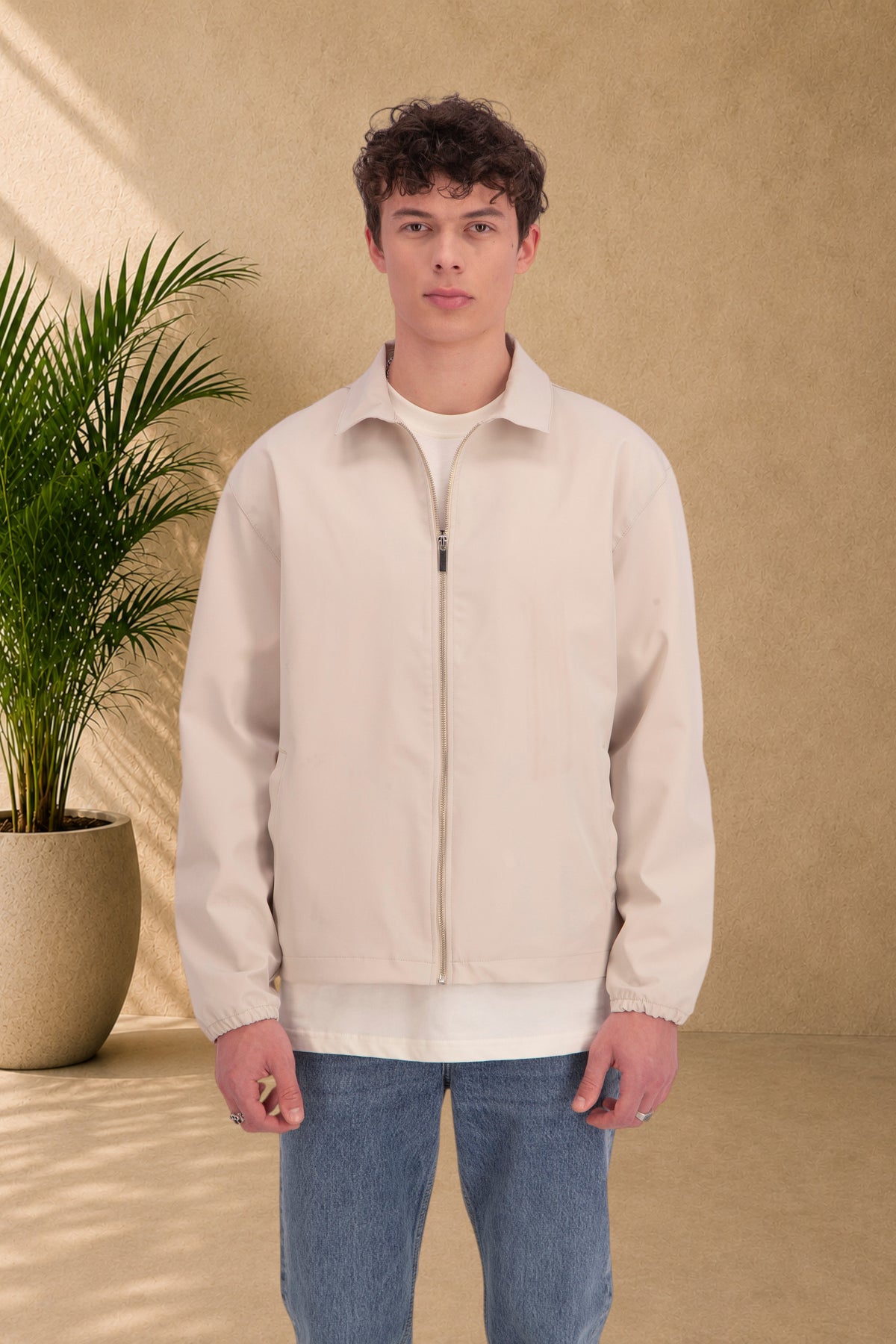 Stayin beige zip-up jacket with a classic collar worn by a male model in a studio setting