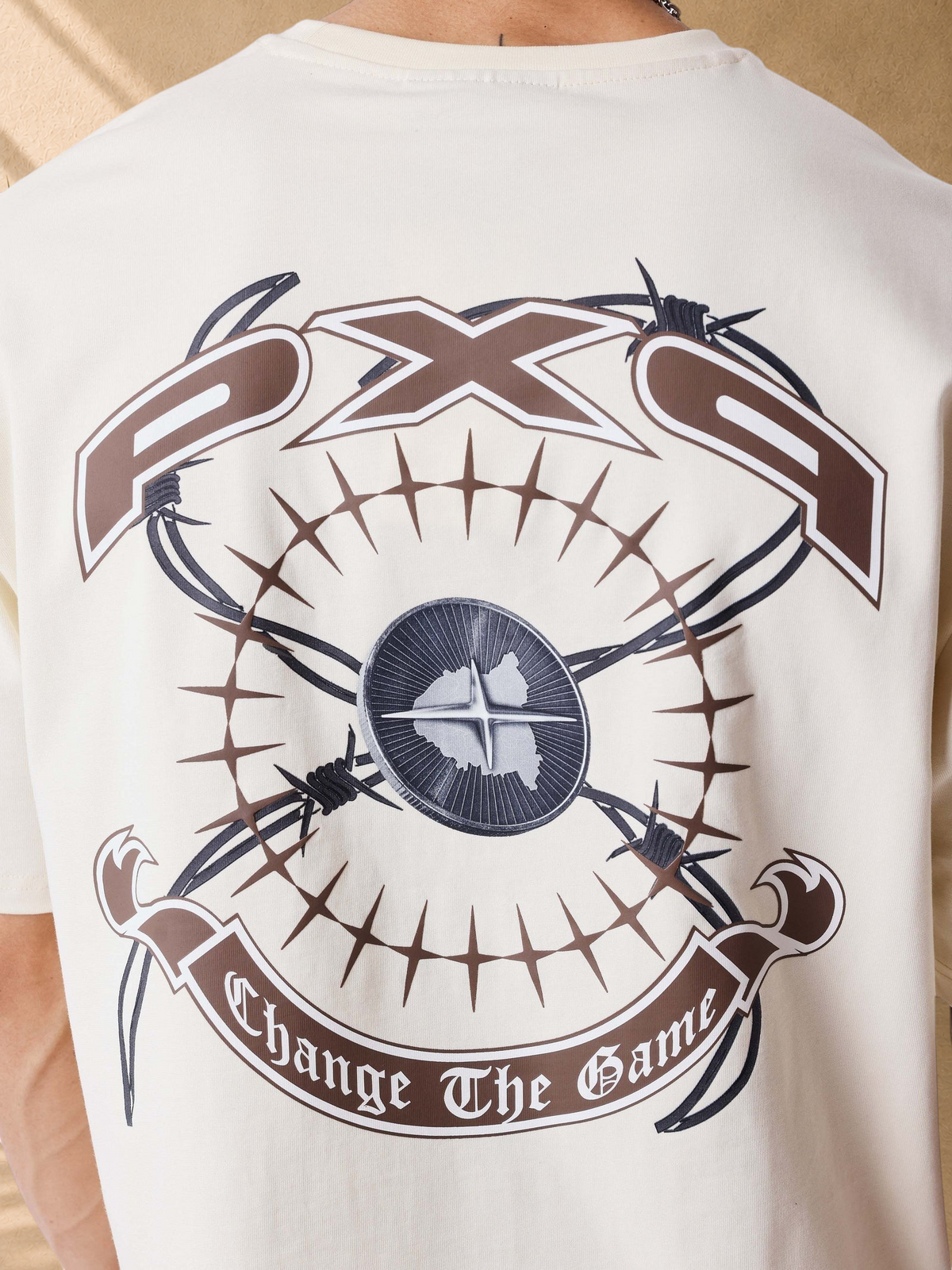 Stayin PXP beige oversized cotton t-shirt featuring a large graphic print with barbed wire and text on the back