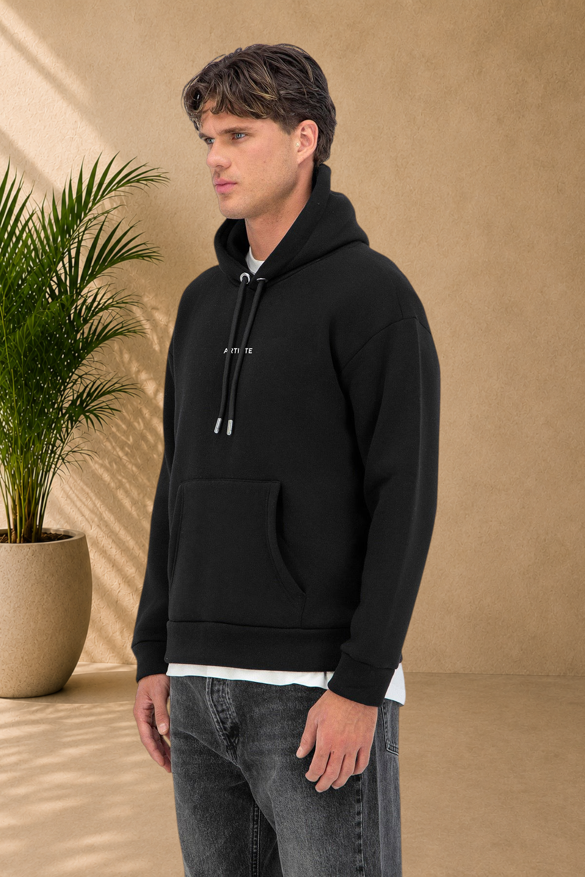 Stayin black quilted hoodie with drawstring hood and front pocket worn by a male model