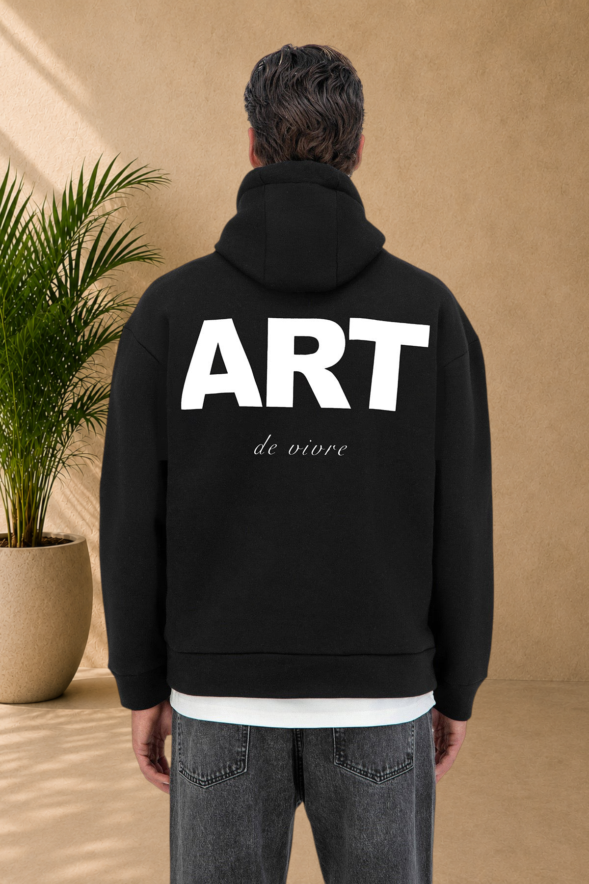 Stayin black quilted hoodie with white ART de vivre graphic print on the back worn by a model