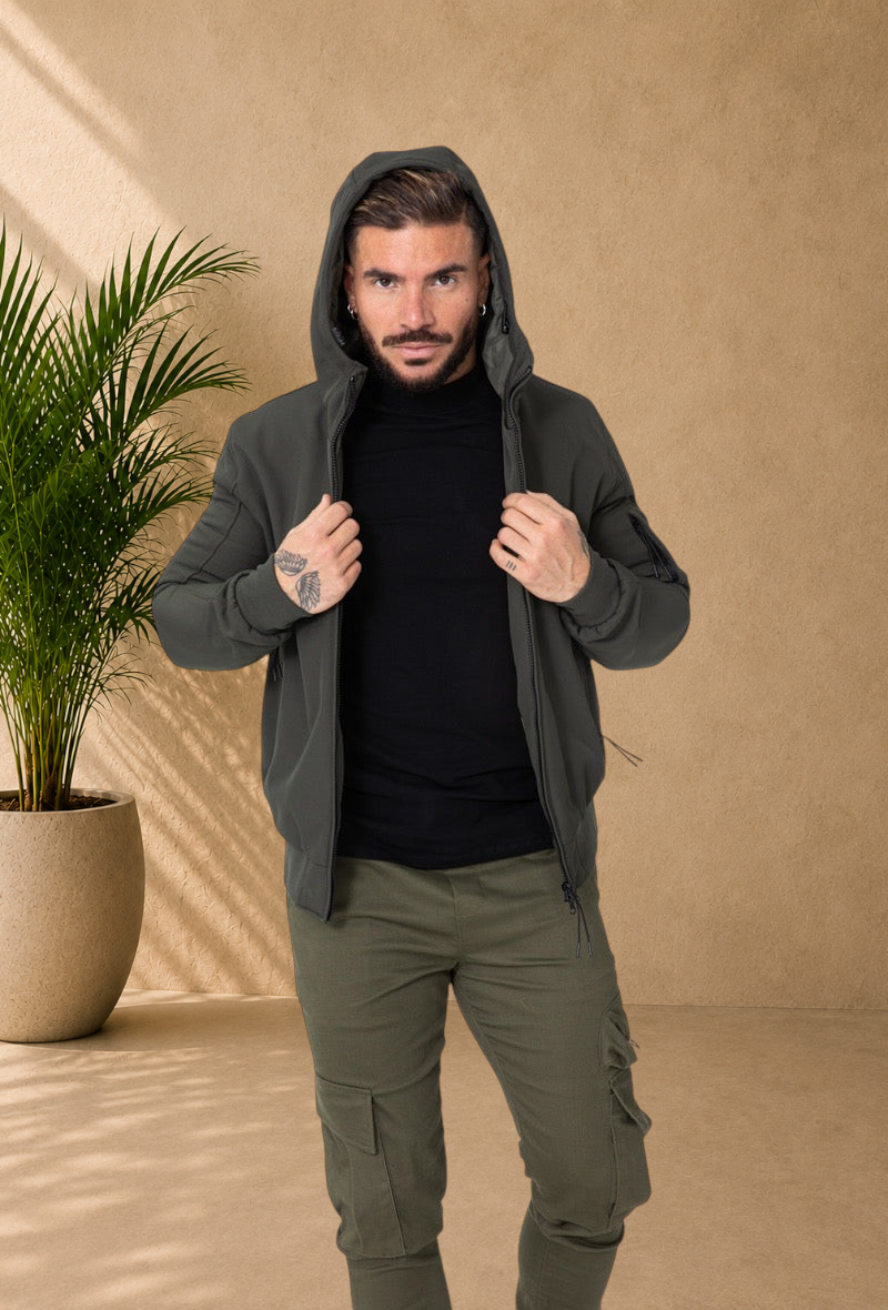 Stayin khaki hooded windbreaker jacket worn by a man in a studio setting