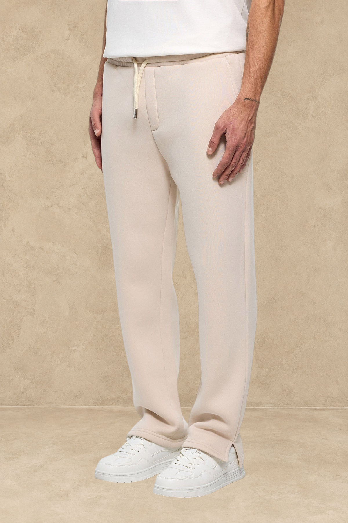 Pantalon jogg beige Stayin avec coupe classique et fente à la cheville porté par un mannequin