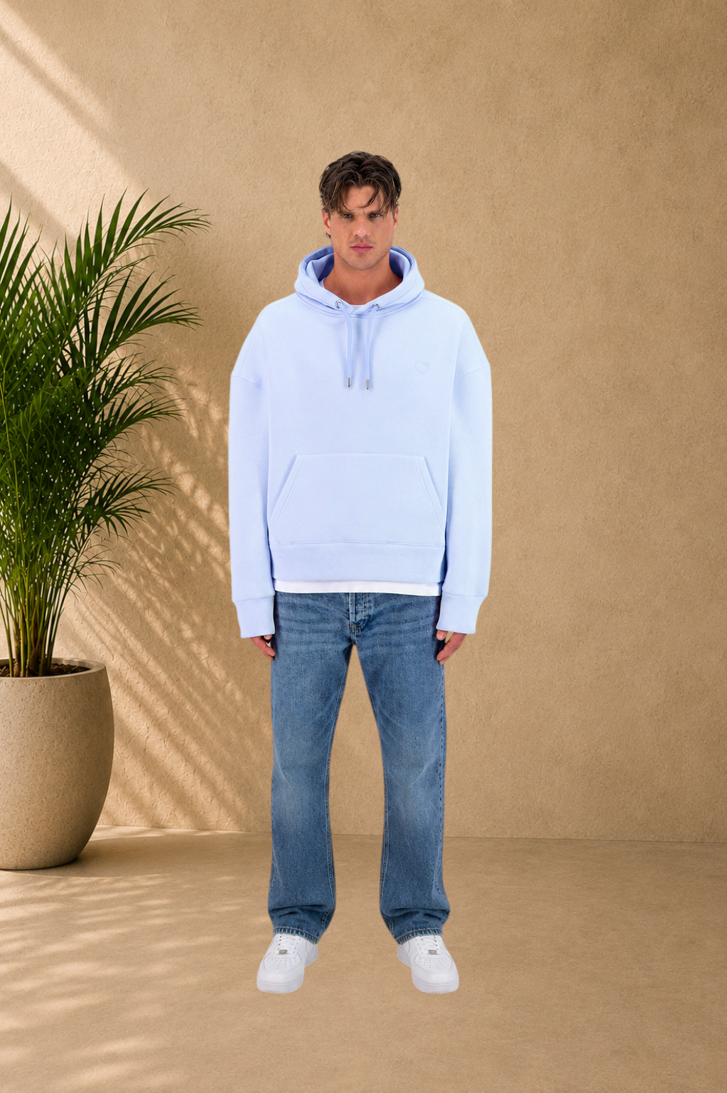 Stayin light blue quilted hoodie with small heart detail worn by a male model with blue jeans and white sneakers