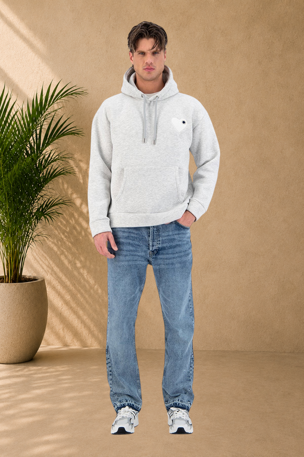 Stayin grey quilted hoodie with a black heart logo worn by a male model with blue jeans and sneakers