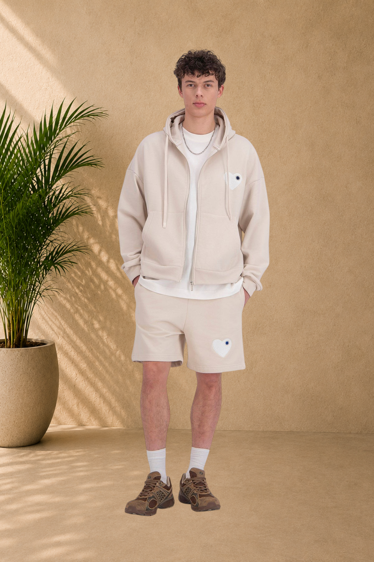 Stayin beige quilted zip-up hoodie with white heart detail worn by a male model with matching shorts