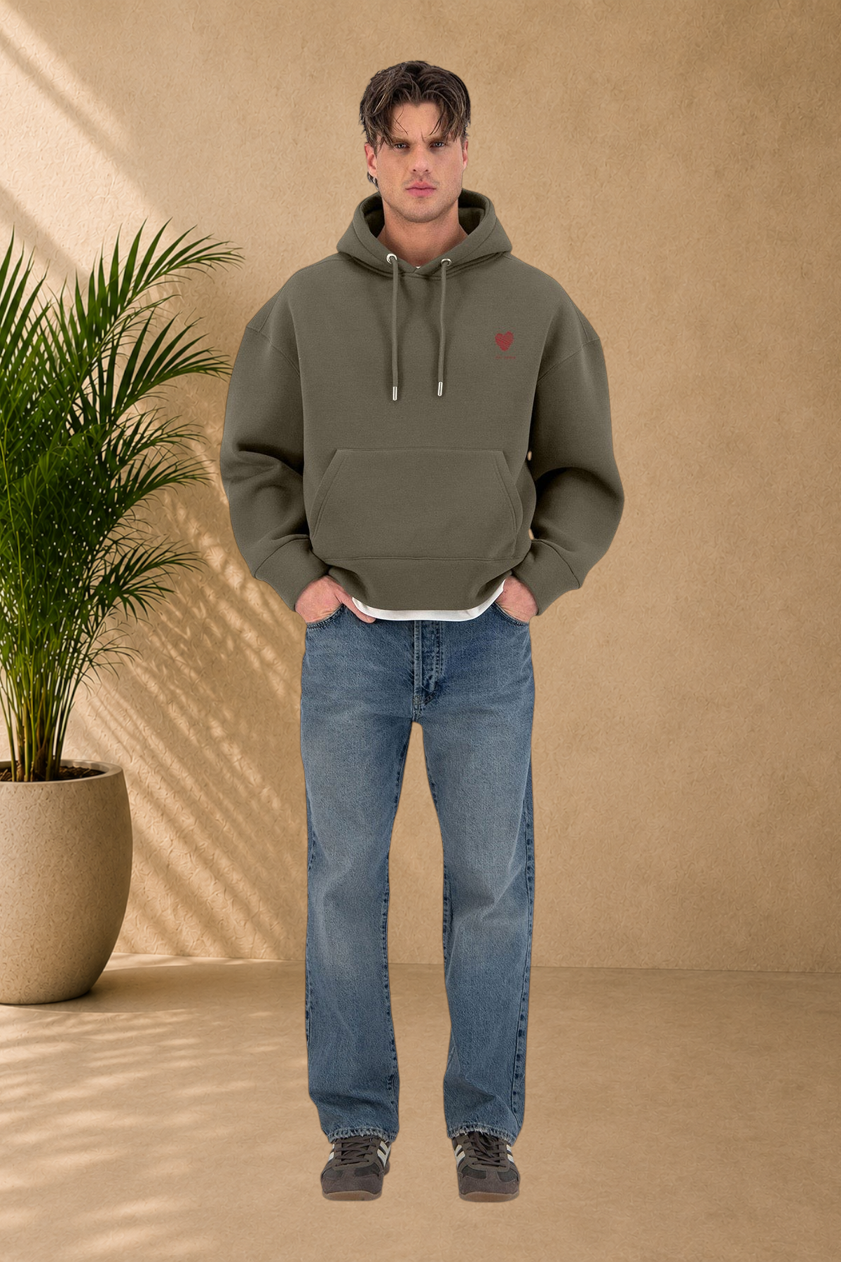 Stayin khaki quilted hoodie featuring a small red heart embroidery on the chest, worn by a male model with blue jeans