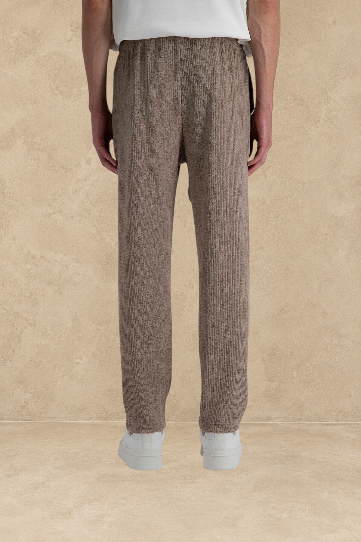 Pantalon plissé marron Stayin à coupe regular porté par un mannequin de dos avec des baskets blanches