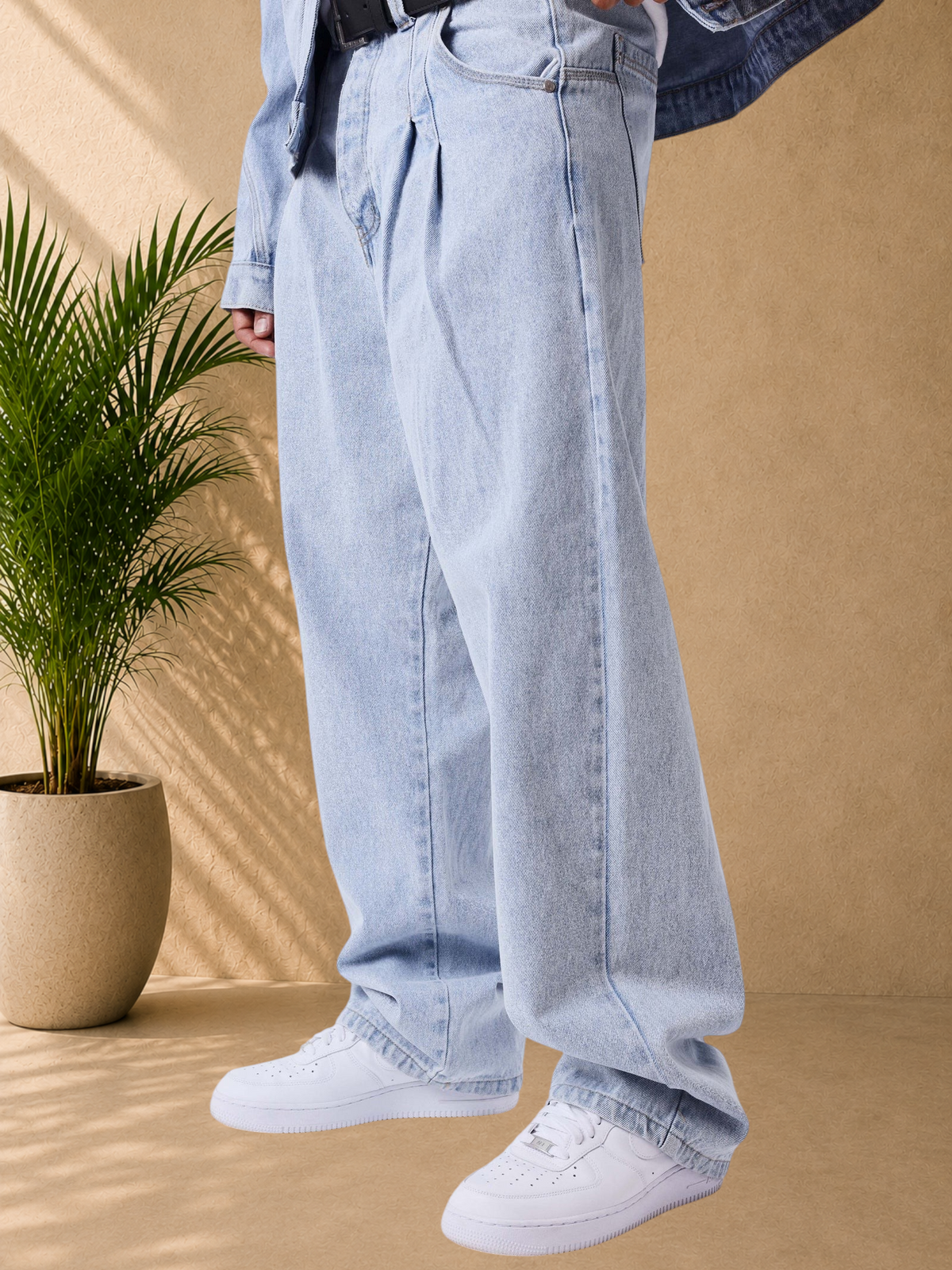 Stayin PXP light blue loose-fit jeans with front pleats, button closure, and side pockets on a model