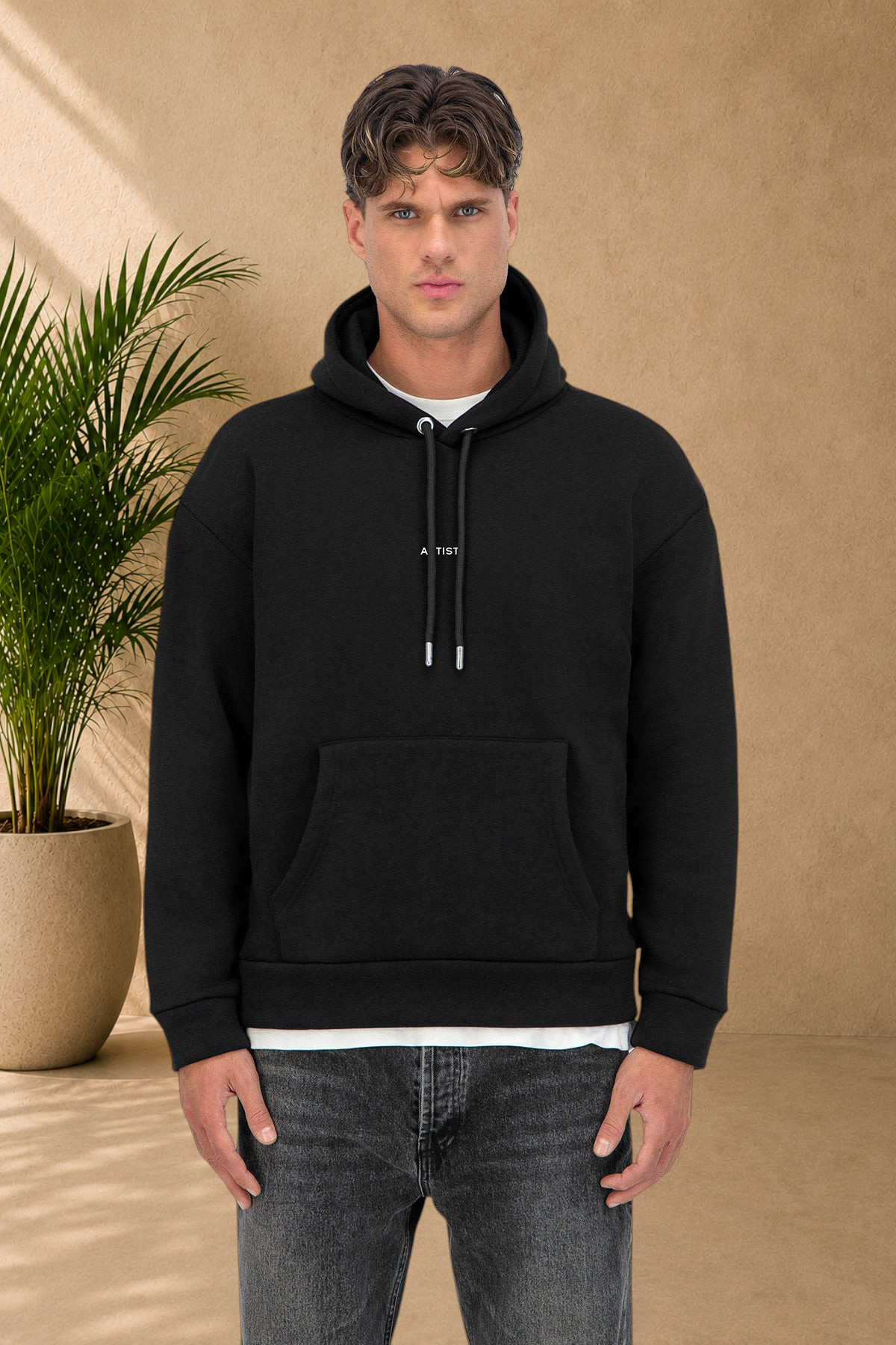 Stayin black quilted hoodie with drawstring hood and ART print worn by a male model on a white background