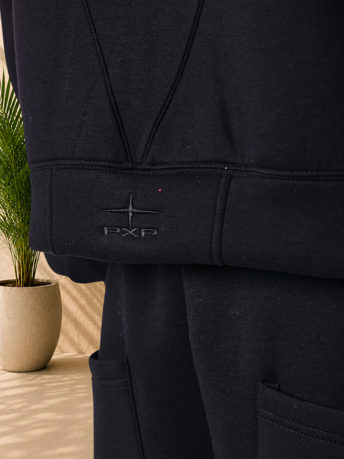 Stayin PXP black neoprene vest with structured panels, ribbed hem, and embroidered logo detail.