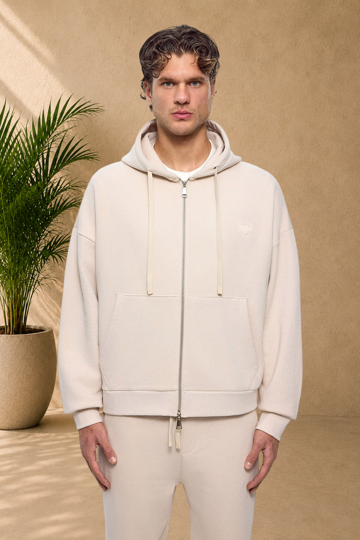 Stayin beige quilted zip-up hoodie with a small heart detail worn by a male model