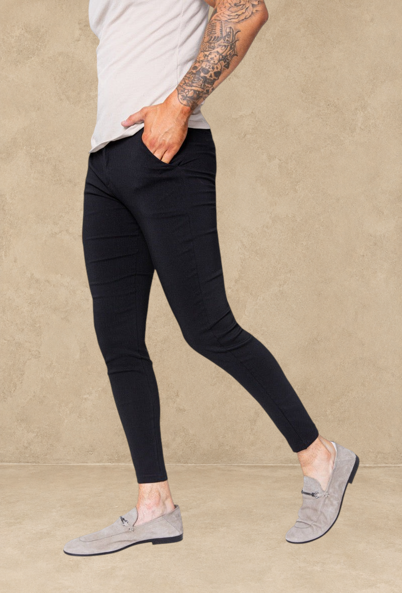 Pantalon Stayin noir coupe cintrée style pince ajusté aux chevilles porté par un homme