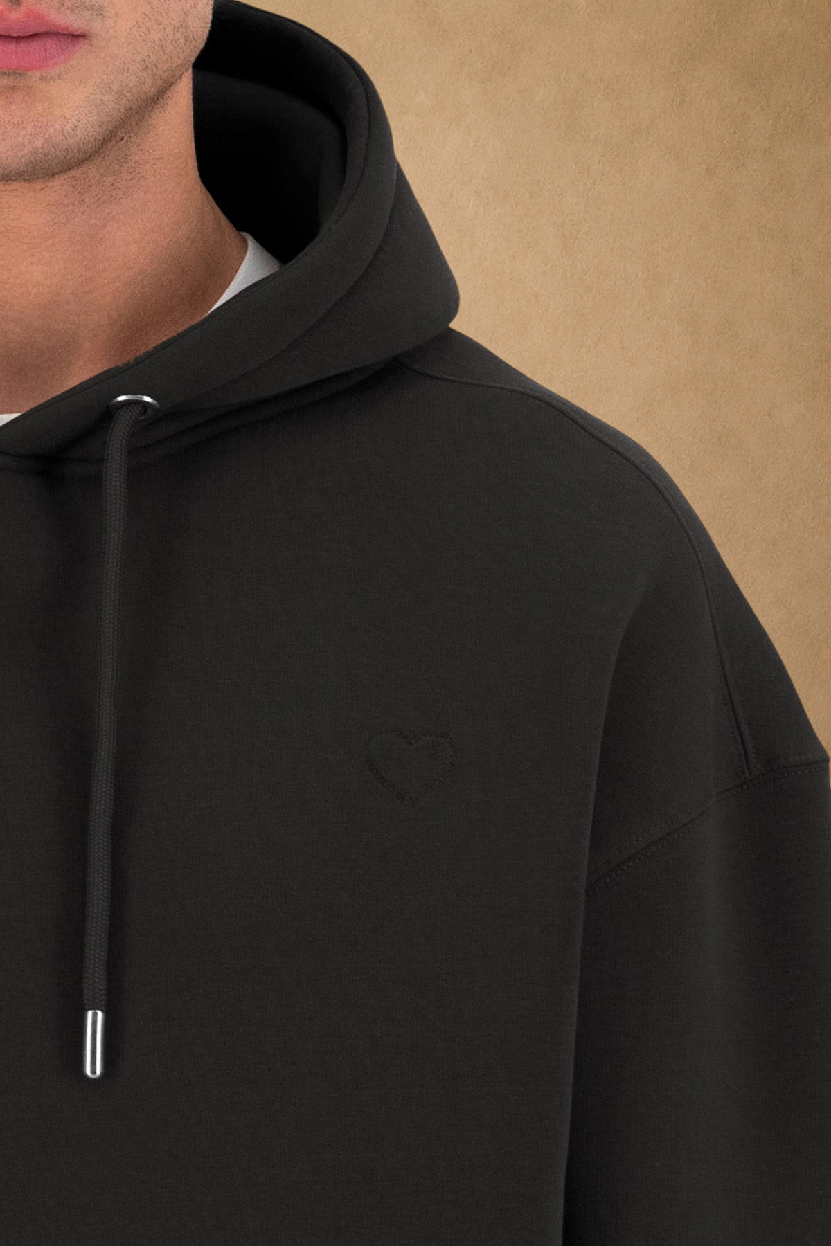Stayin black quilted hoodie with a subtle embroidered heart detail on the chest worn by a model