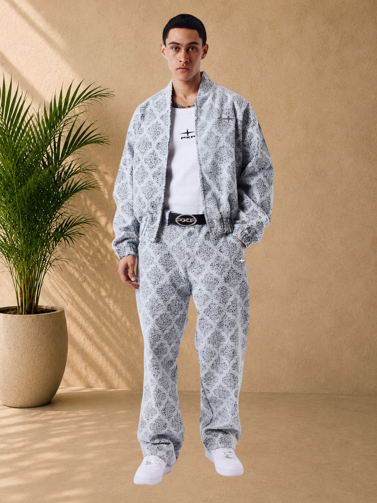 Stayin model wearing an oversized grey patterned zip-up jacket and matching trousers with ribbed cuffs.