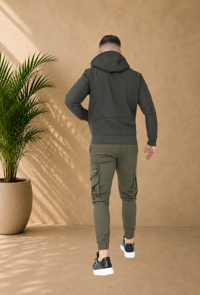 Stayin hooded windbreaker jacket in khaki worn by a man with matching cargo joggers and black sneakers