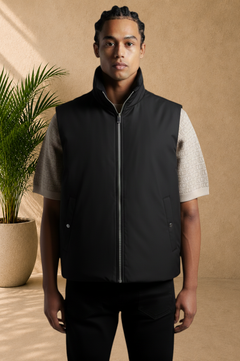 Stayin reversible black and beige zip-up sleeveless vest worn by a man in a studio setting