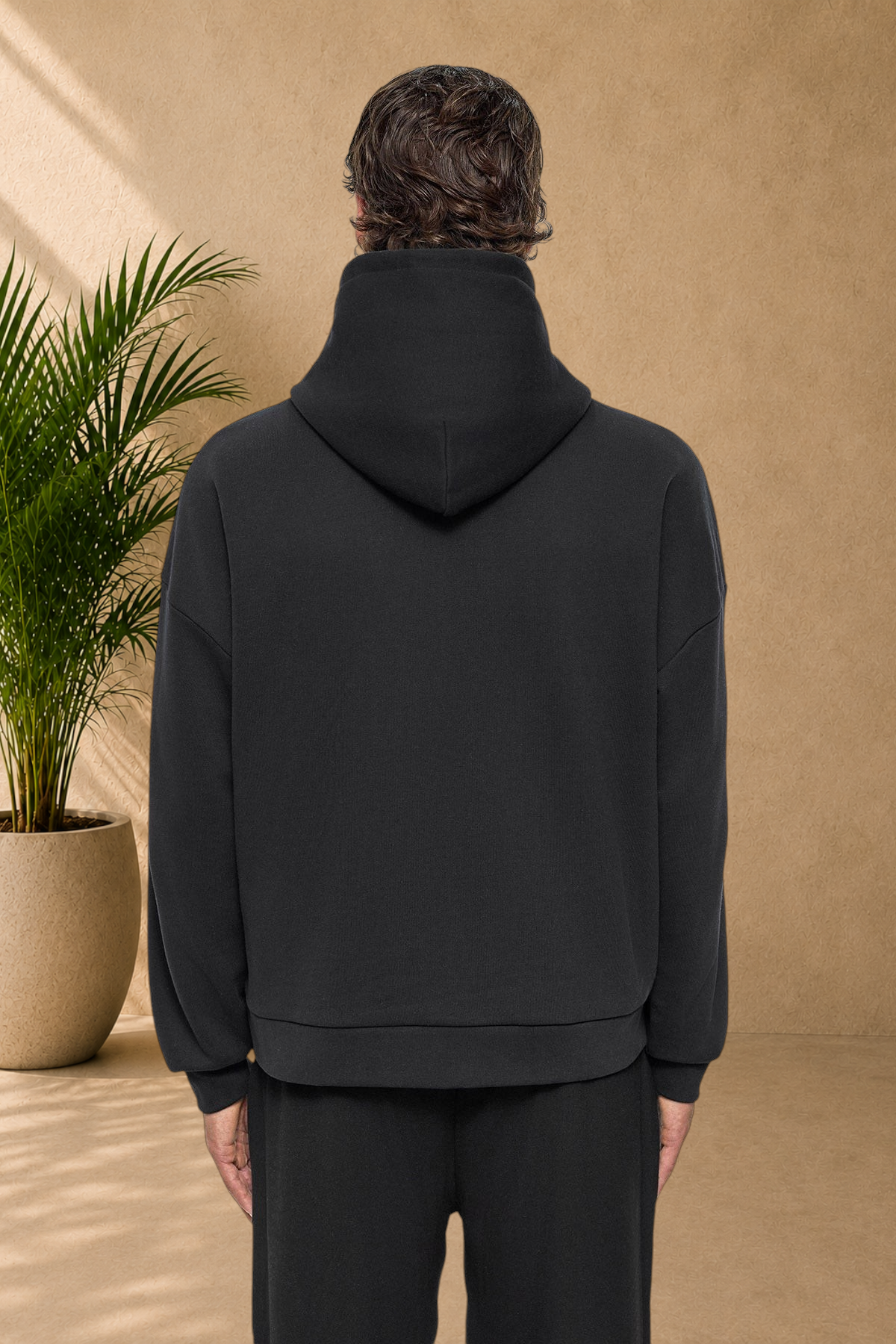 Back view of a person wearing a Stayin black quilted hooded sweatshirt with a cozy, thick fit.