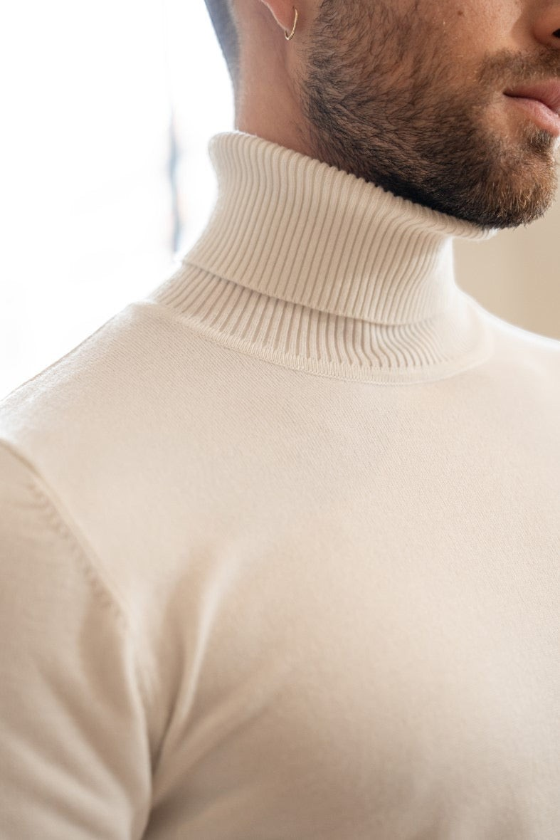 Stayin white slim-fit turtleneck sweater worn by a man, featuring a ribbed collar and soft knit fabric.