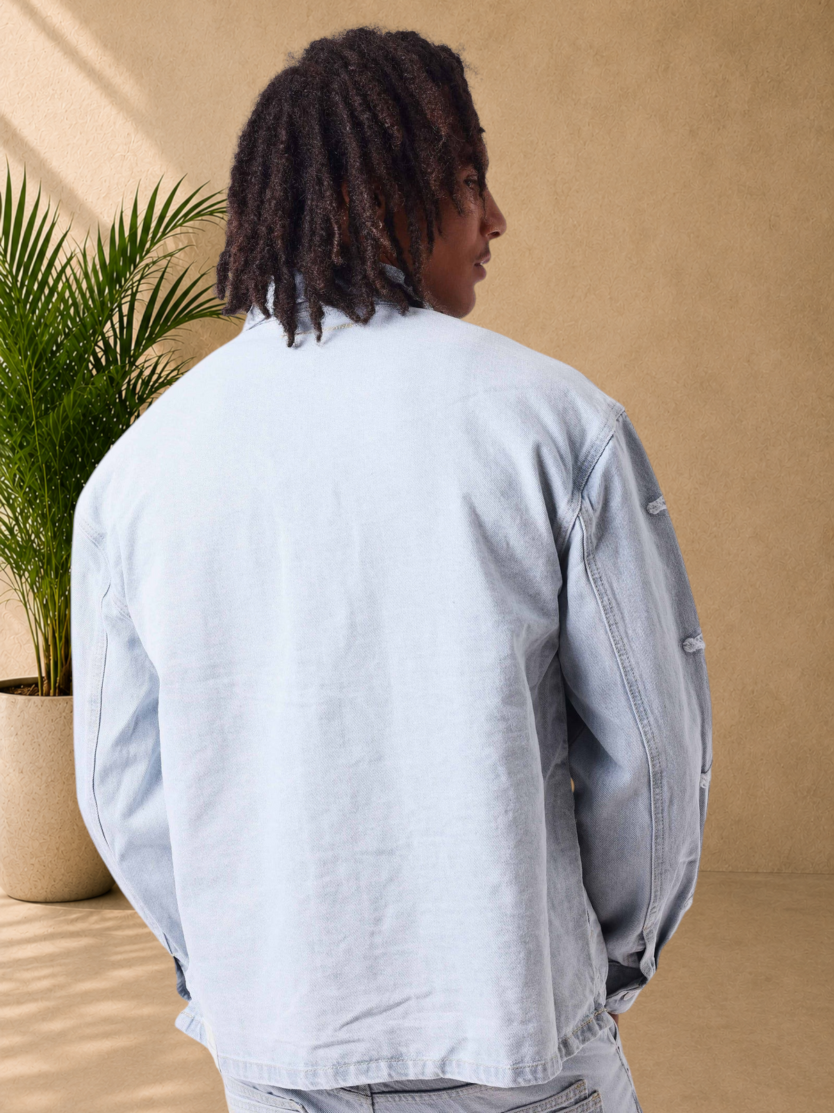 Stayin light blue loose-fit denim jacket with Polaris sleeve detailing worn by a model, back view.