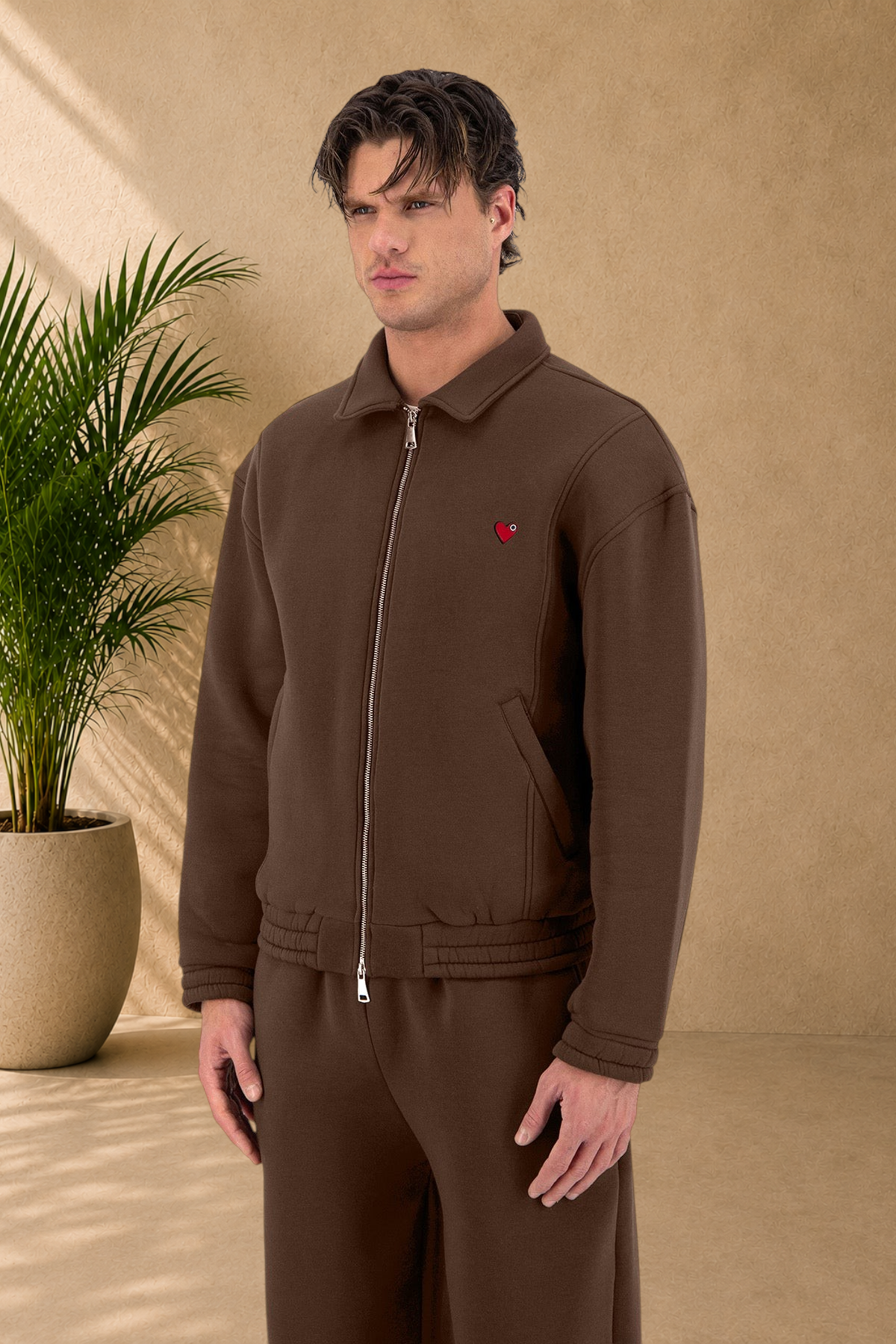 Stayin brown oversized padded jacket with a small red heart detail on the chest worn by a male model