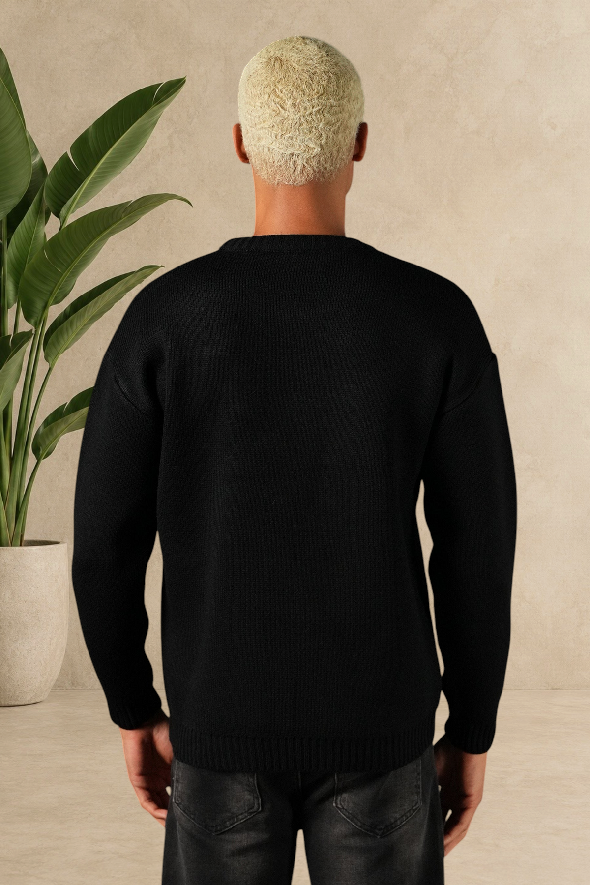 Vue arrière d'un homme portant un pull Stayin noir en maille épaisse à col rond, coupe droite et style minimaliste.