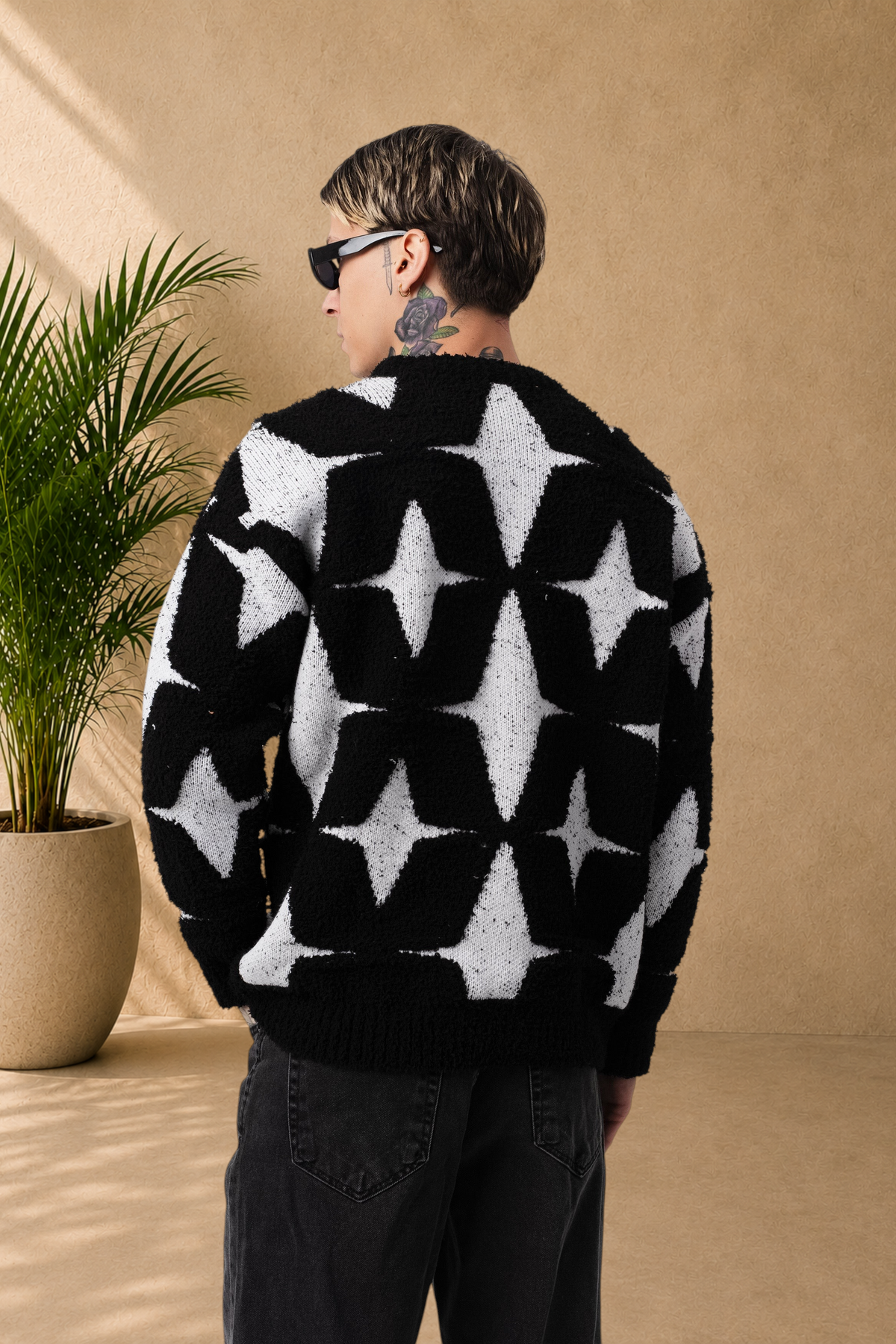 Stayin fluffy black and white sweater with star pattern worn by a man from the back view