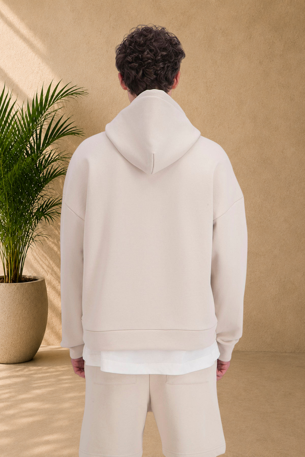 Stayin beige quilted zip-up hoodie worn by a model, back view showing thick fabric and comfortable fit.