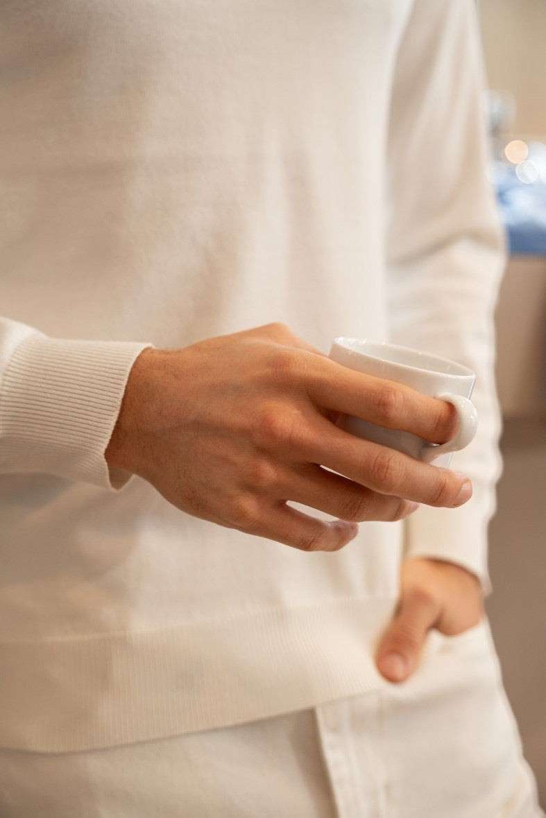 Stayin white slim-fit turtleneck sweater worn by a model holding a small white cup