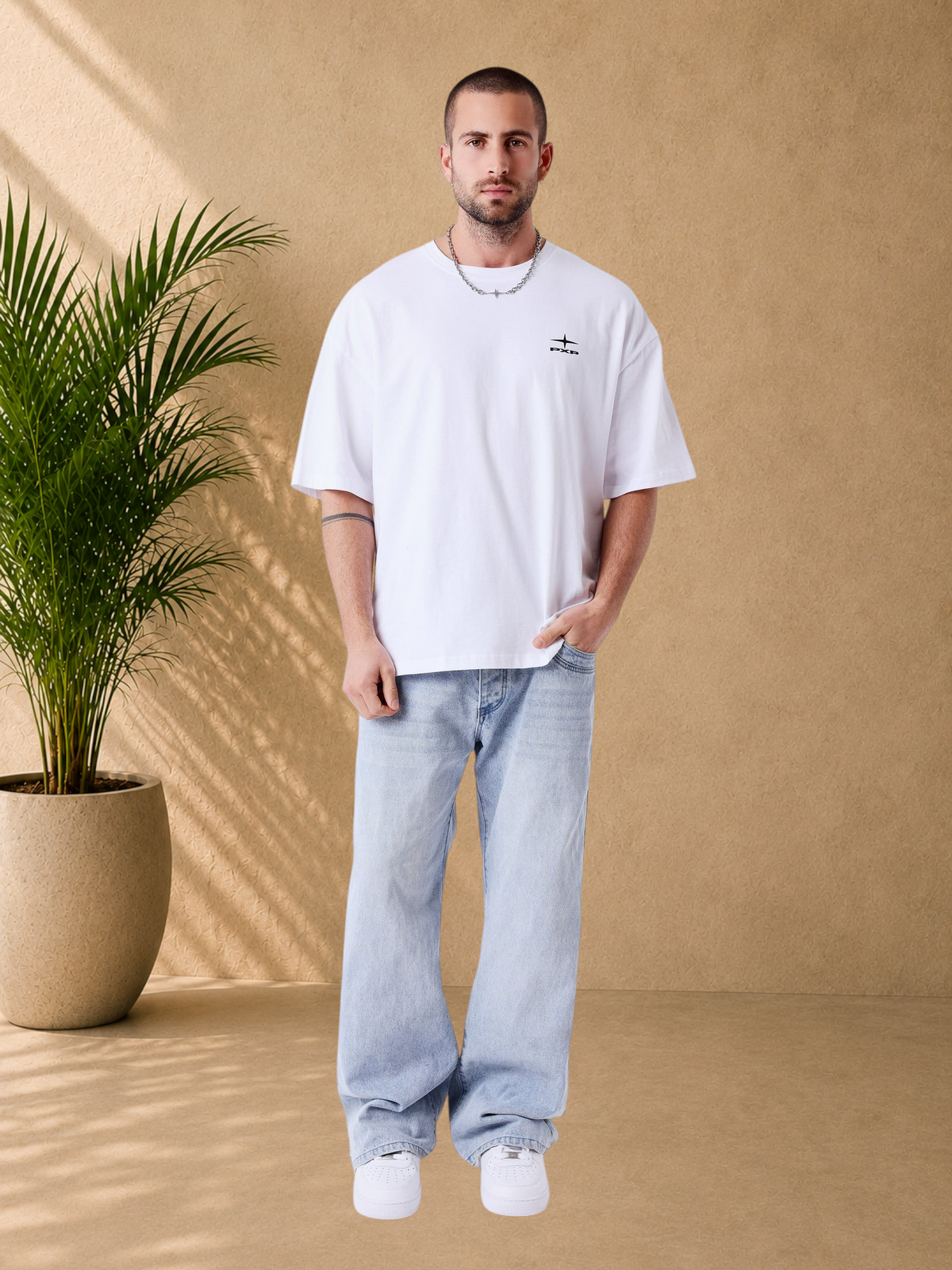 Stayin PXP white boxy fit cotton t-shirt with small chest logo worn by a male model with light blue jeans