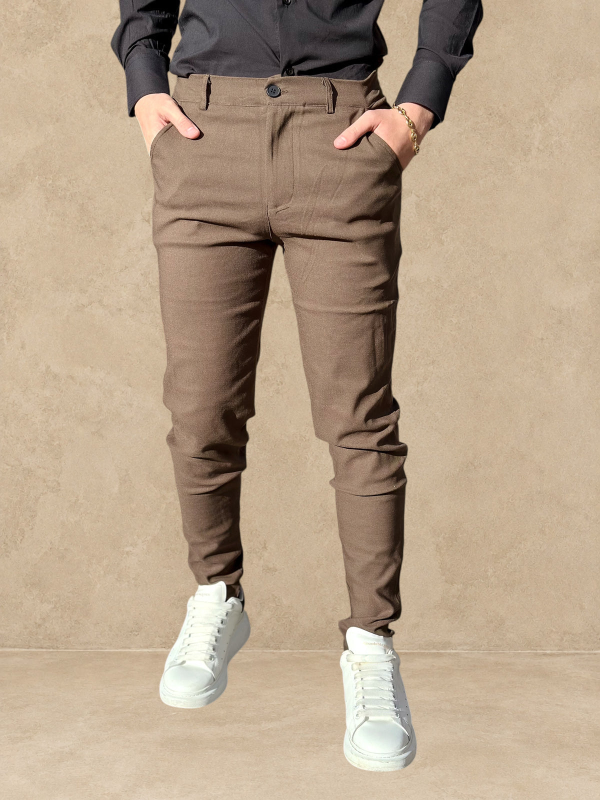 Pantalon Stayin marron coupe cintrée style pince porté par un mannequin avec une chemise noire et des baskets blanches