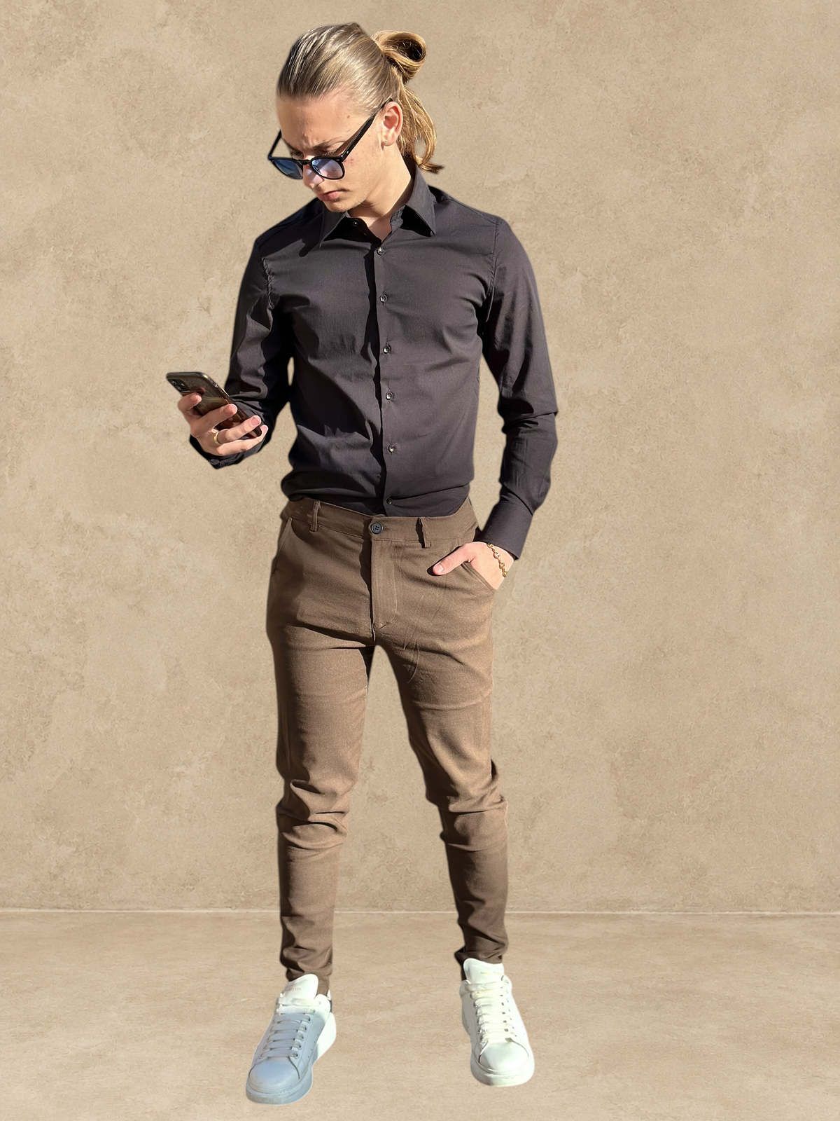 Homme portant un pantalon cosy marron Stayin coupe cintrée avec une chemise noire et des baskets blanches en extérieur